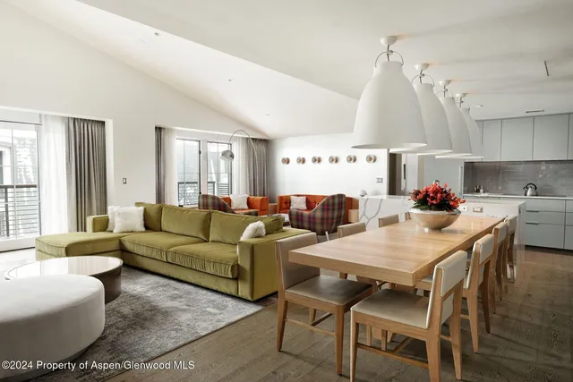 a living room with furniture a large window and a chandelier