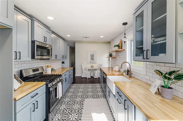 a large kitchen with granite countertop a sink and a stove