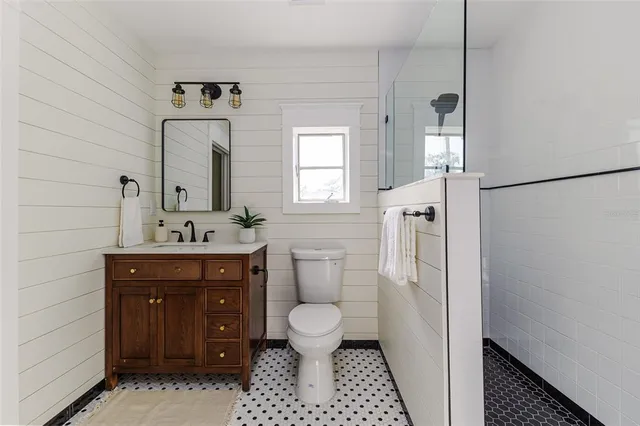 a bathroom with a sink a toilet and a mirror