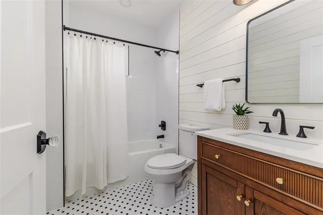 a bathroom with a granite countertop sink a toilet and shower