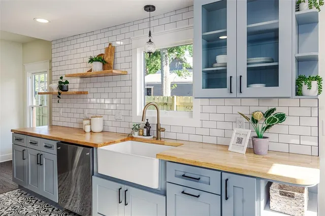 a kitchen with stainless steel appliances a sink a potted plant and cabinets