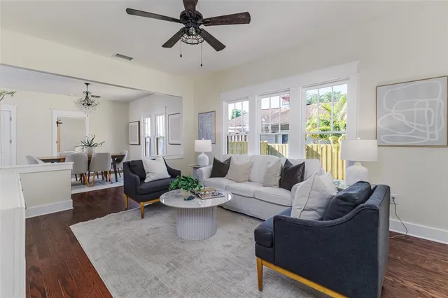 a living room with furniture kitchen view and a window