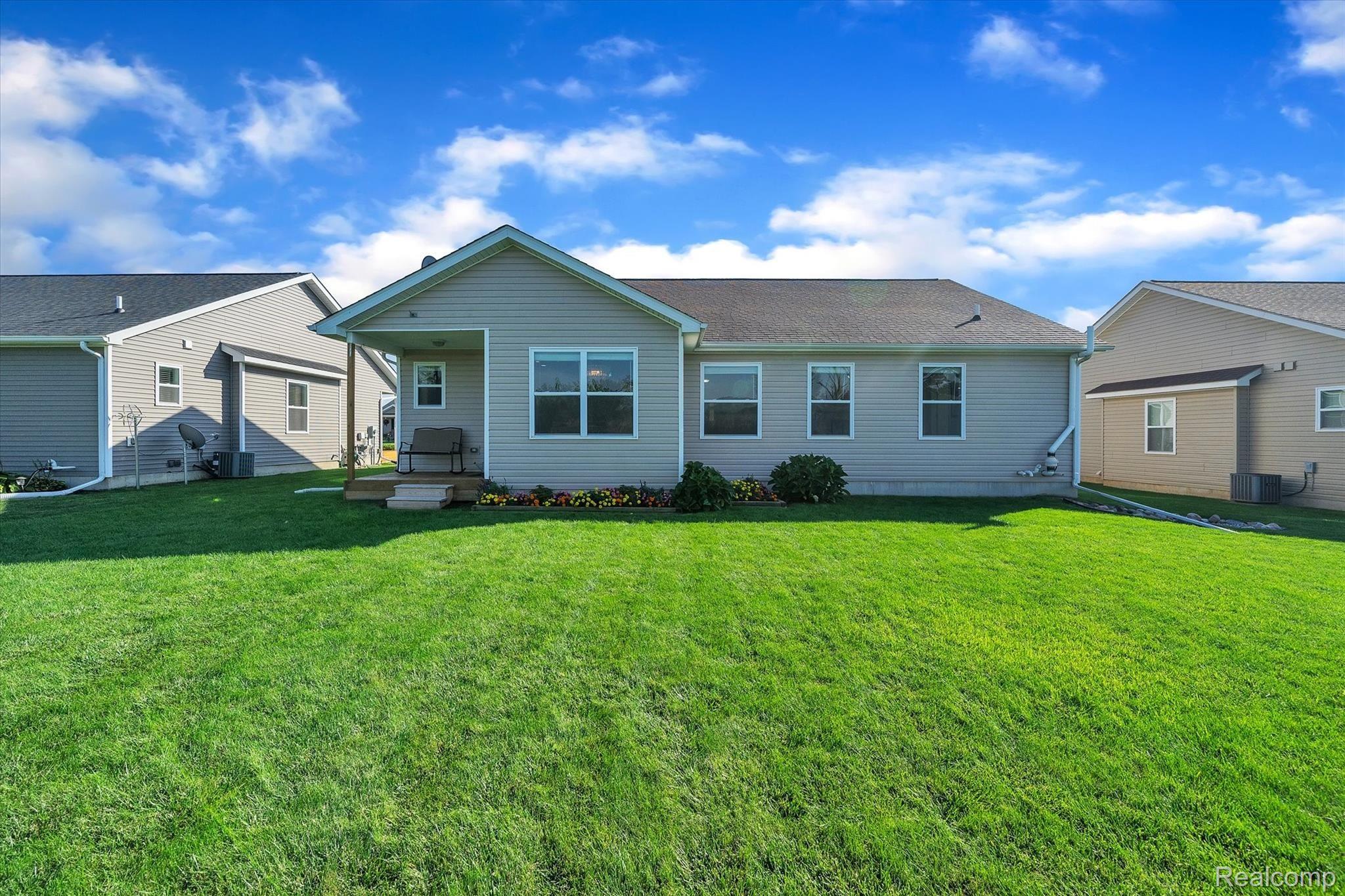 8116 Eagle Ridge Lane Fowlerville, MI 48836 - Photo 16 of 36 Rear of Home with Flower Bed
