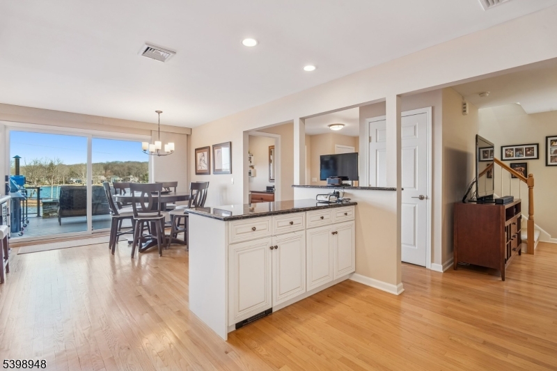 305 Kingsland Road Landing, NJ 07850 - Photo 12 of 40 a open kitchen with stainless steel appliances granite countertop a stove top oven a sink a dining table and chairs with wooden floor