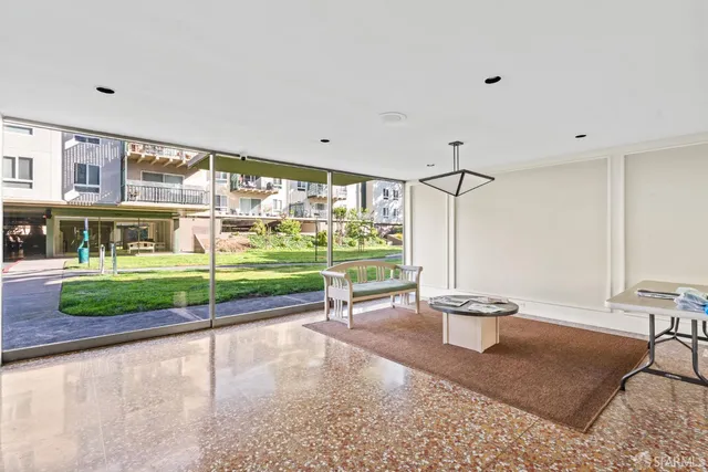 a backyard of a house with table and chairs plants and large trees