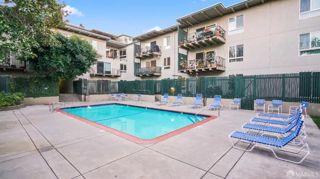 a view of backyard with swimming pool and seating space