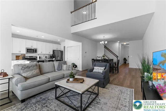 a kitchen with stainless steel appliances granite countertop a table chairs sink refrigerator and cabinets