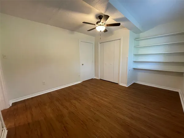 a view of empty room with wooden floor