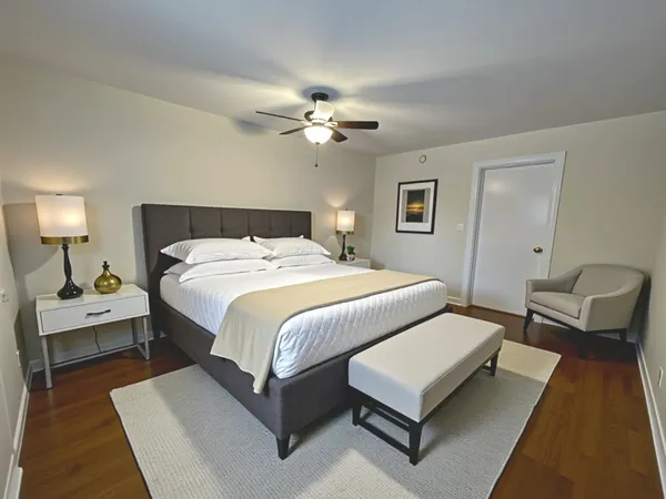 a bedroom with a bed couch and a chandelier