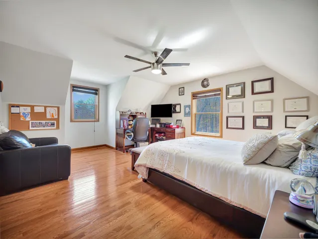 a bedroom with a large bed a flat tv screen and dresser