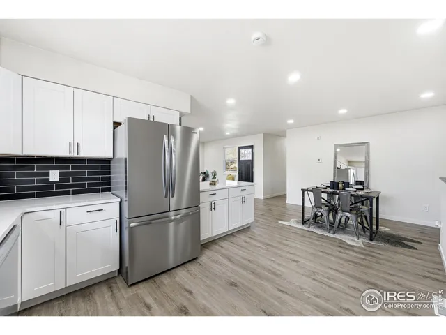 a kitchen with stainless steel appliances a refrigerator and wooden floor