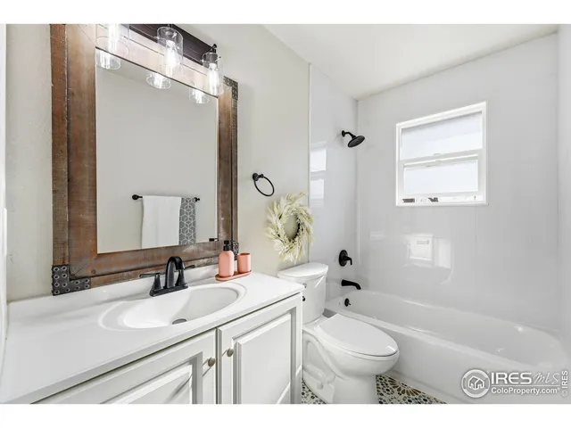 a bathroom with a granite countertop sink toilet a large mirror a bathtub and shower