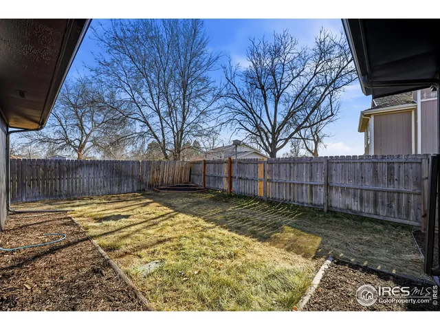 a view of backyard with wooden fence