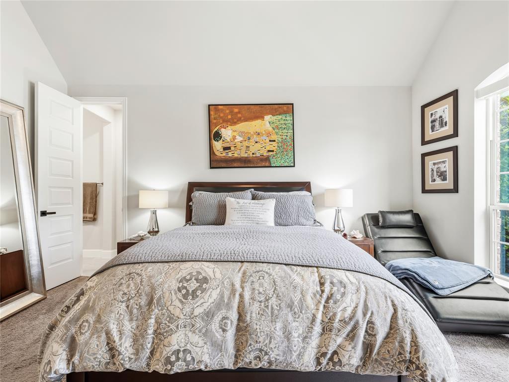 15340 Crape Myrtle Road Frisco, TX 75035 - Photo 19 of 40 Spacious bedroom featuring vaulted ceilings, plush carpet flooring, a large window, and a paneled interior door with black hardware