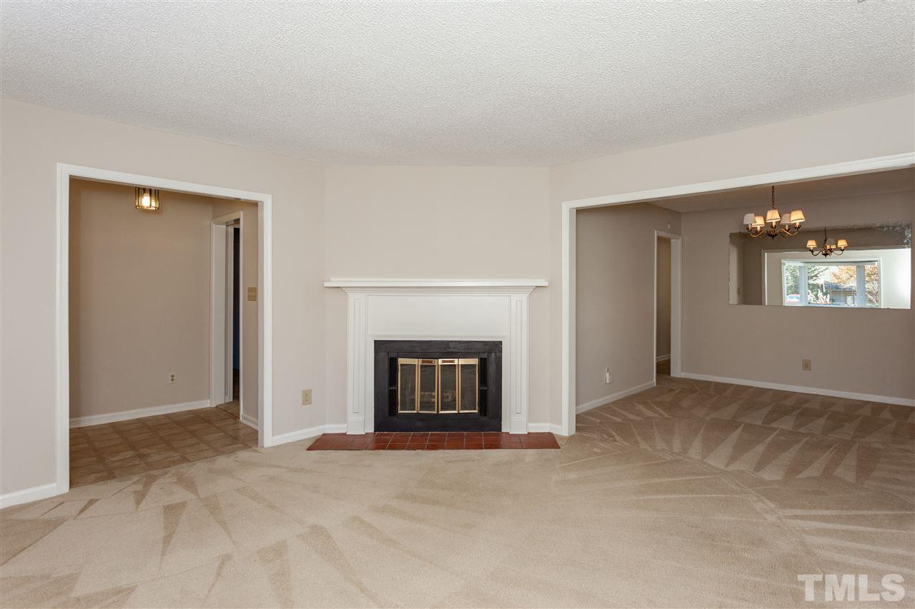 8027 Brown Bark Place Raleigh, NC 27615 - Photo 3 of 19 an empty room with a fireplace and window