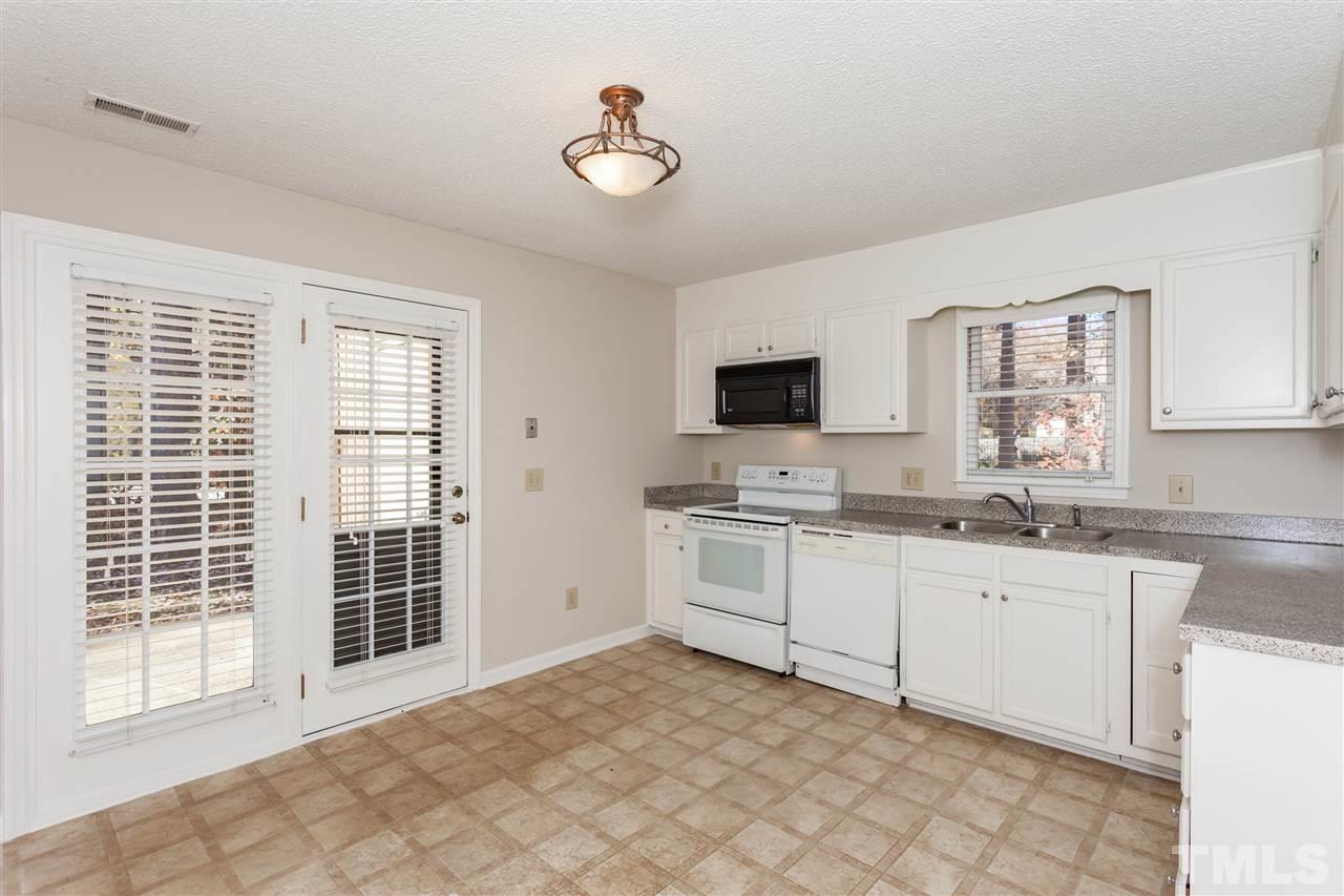 8027 Brown Bark Place Raleigh, NC 27615 - Photo 5 of 19 a kitchen with granite countertop a sink appliances cabinets and furniture