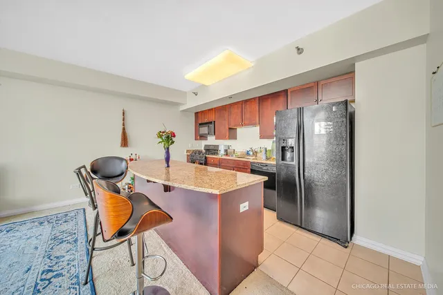 a kitchen with stainless steel appliances granite countertop a refrigerator a stove a sink a dining table and chairs