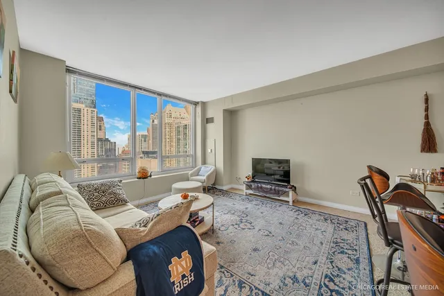 a living room with furniture a flat screen tv and a window