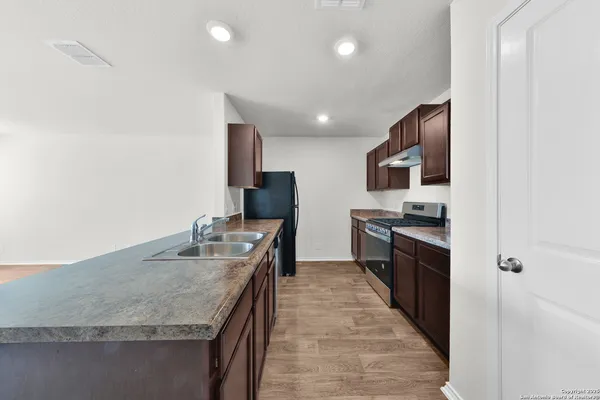 a kitchen with stainless steel appliances granite countertop a sink refrigerator and microwave