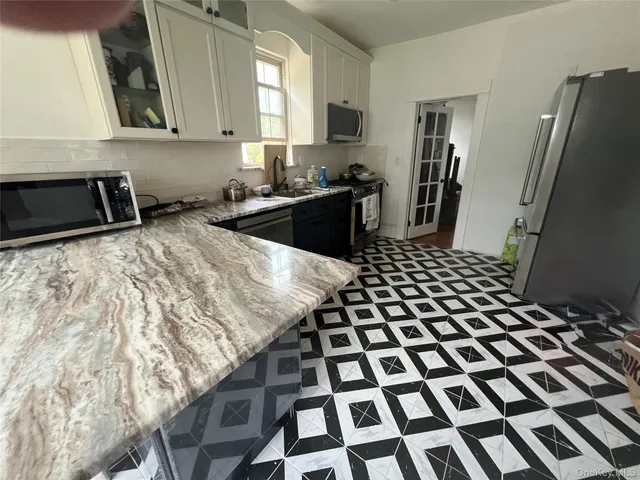 a kitchen with a sink a stove and a refrigerator
