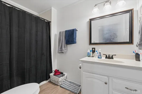 a kitchen with stainless steel appliances a refrigerator a stove a dining table and chairs with wooden floor