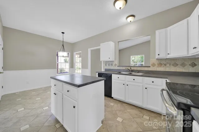 a kitchen with granite countertop a sink stove and cabinets