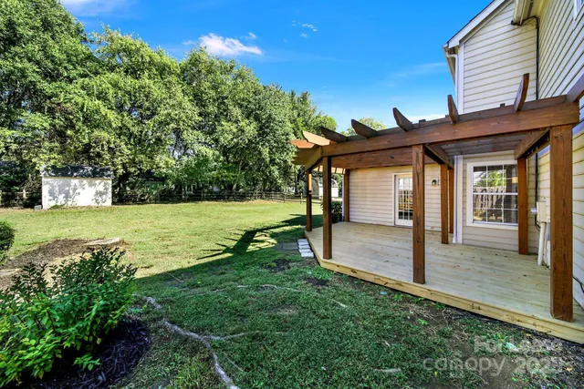 a view of a house with backyard and a tree