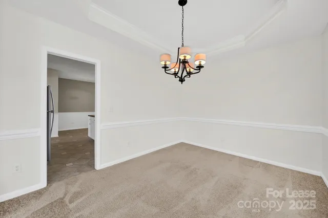 a view of a room with a hanging light and kitchen