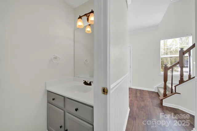 a view of a hallway with wooden floor and windows