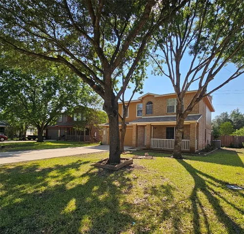 a view of a house with a yard and large trees