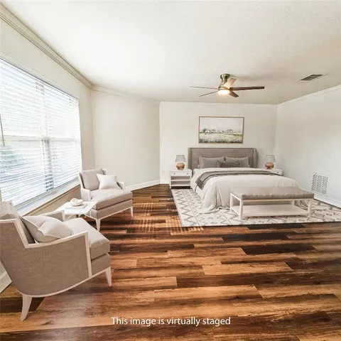 a bedroom with furniture and a large window