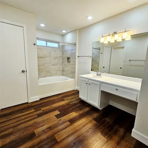 a bathroom with a sink mirror and a bathtub