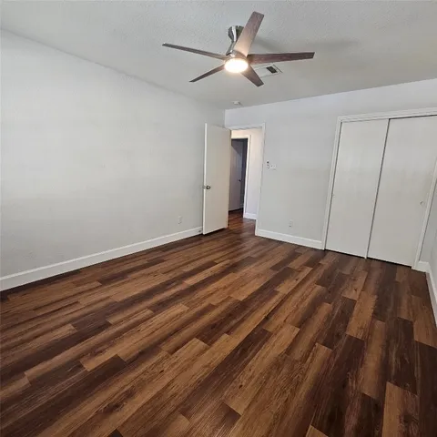 a view of room with hardwood floor and ceiling fan