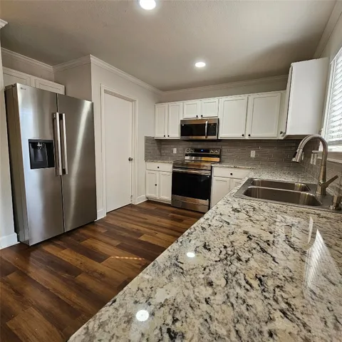 a kitchen with stainless steel appliances granite countertop a refrigerator sink and stove