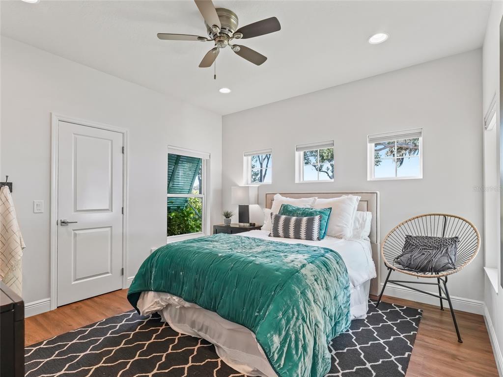 12943 Southeast Sunset Harbor Road Weirsdale, FL 32195 - Photo 40 of 87 a bedroom with a bed and a chandelier