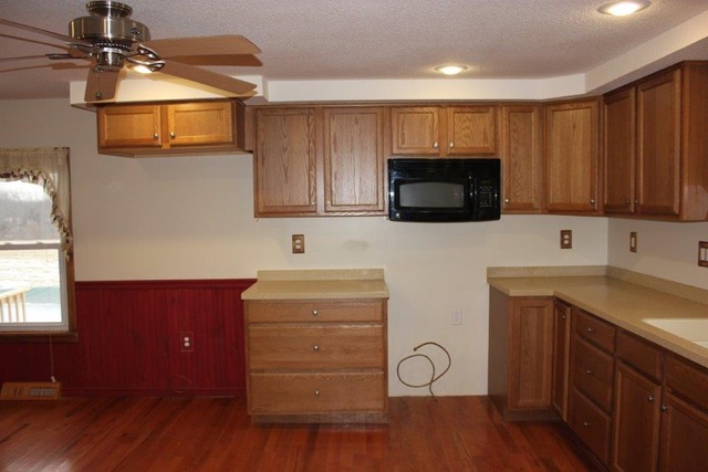 11830 Nelson Road Morrison, IL 61270 - Photo 3 of 15 a kitchen with stainless steel appliances granite countertop a stove a sink and a microwave with wooden floor
