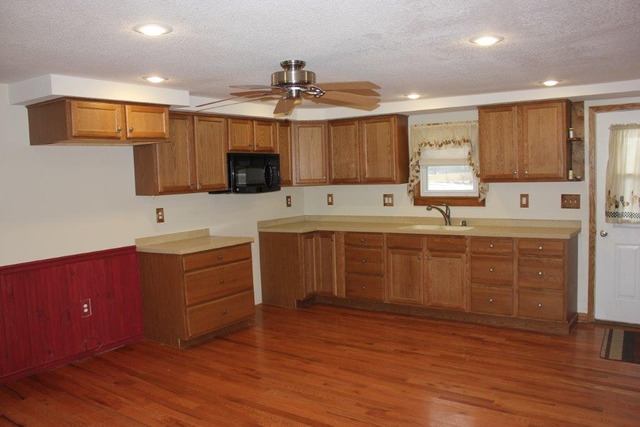 11830 Nelson Road Morrison, IL 61270 - Photo 4 of 15 a kitchen with kitchen island granite countertop a sink cabinets and wooden floor