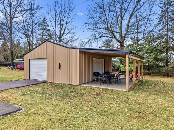 a view of house with outdoor seating and covered with trees