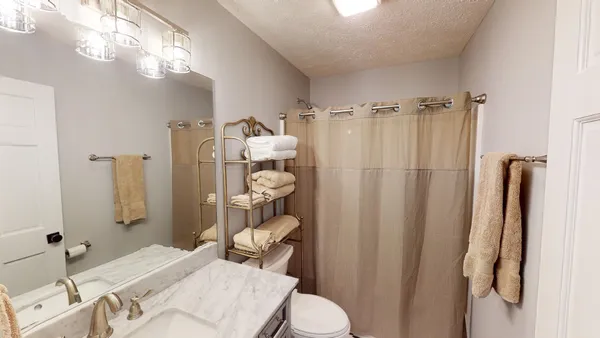 a bathroom with a sink a toilet and shower curtain