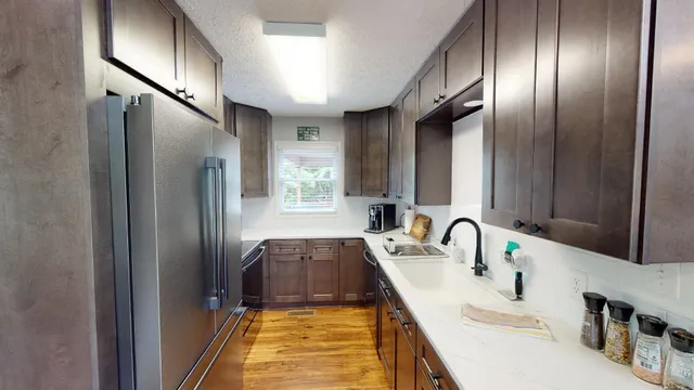 a kitchen with stainless steel appliances a sink and a refrigerator