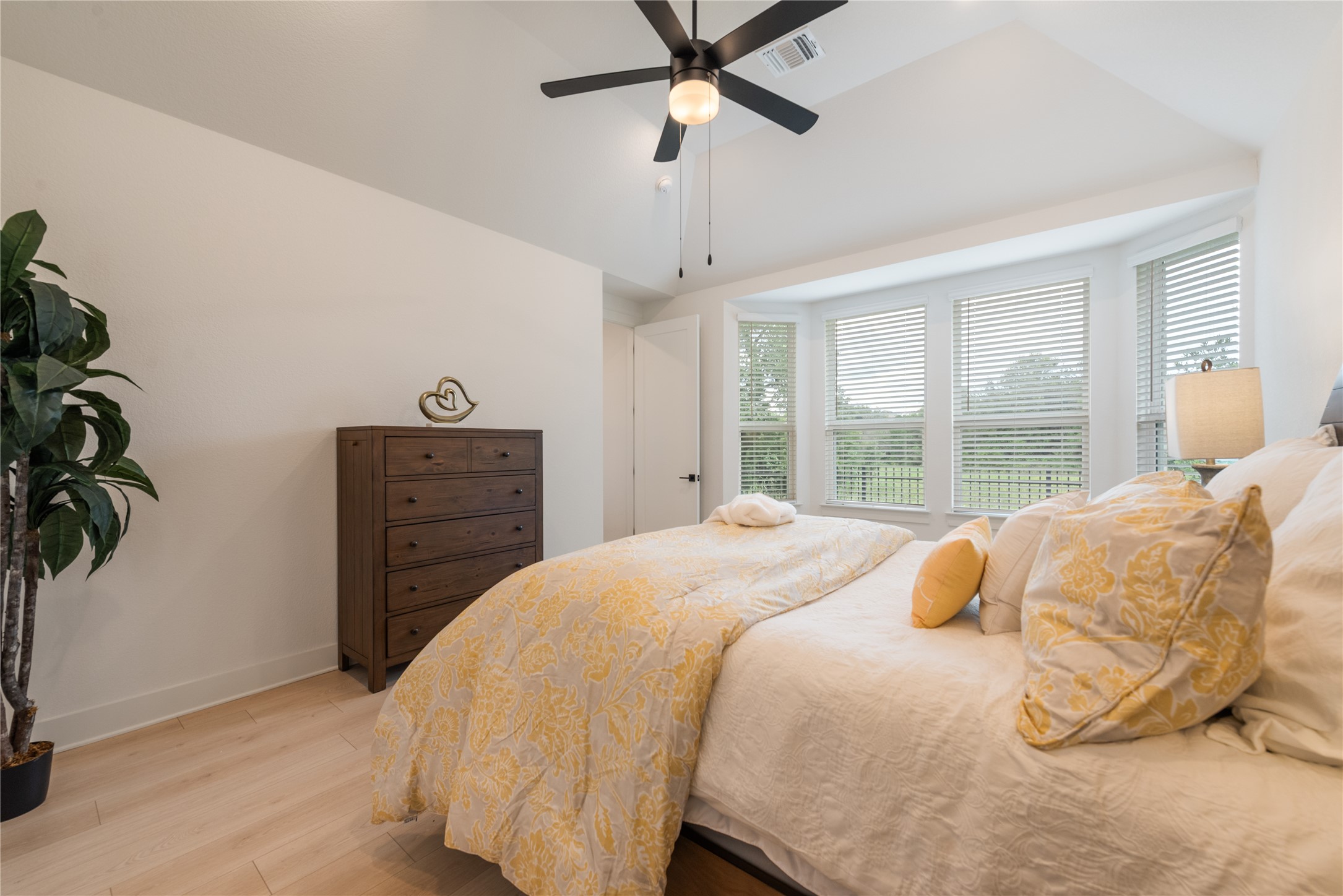 294 Kimble Creek Loop Kyle, TX 78640 - Photo 14 of 40 A tranquil bedroom retreat features bay windows overlooking natural surroundings and a welcoming ambiance.