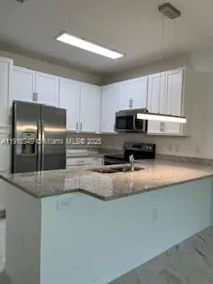 a kitchen with stainless steel appliances granite countertop a refrigerator a stove a sink a stove a microwave and a refrigerator