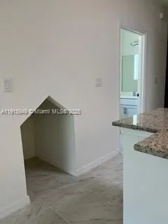 a room with a granite countertop sink and cabinets