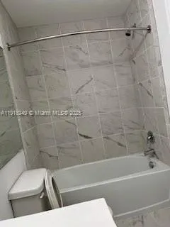 a bathroom with a toilet and a bath tub