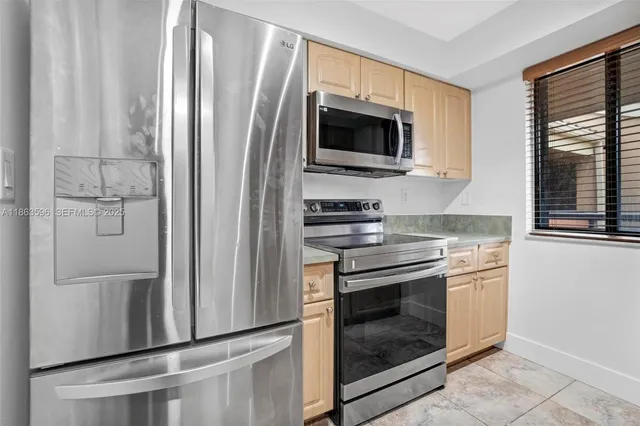 a kitchen with stainless steel appliances a stove microwave and refrigerator