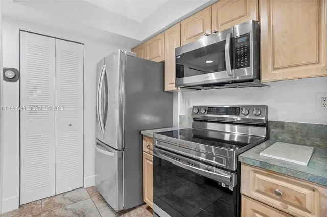 a kitchen with stainless steel appliances granite countertop a refrigerator and a microwave