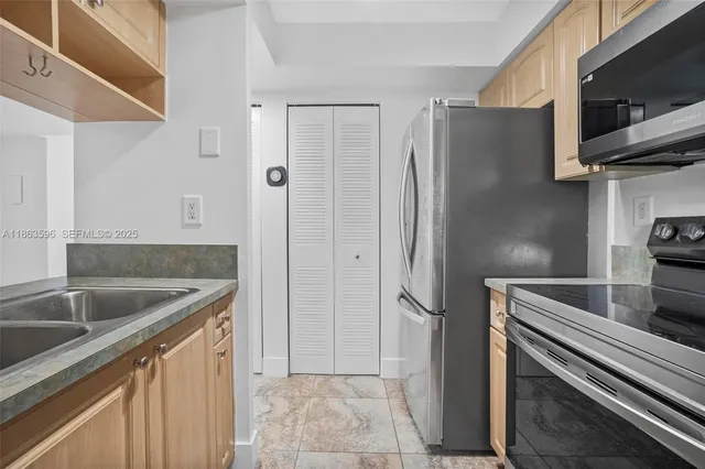 a kitchen with stainless steel appliances granite countertop a refrigerator and a sink