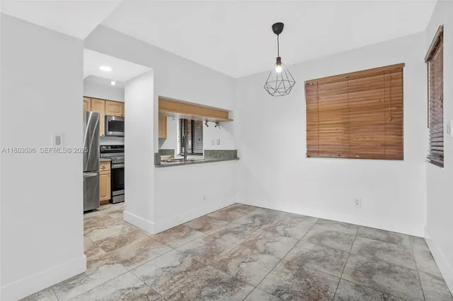 a view of a kitchen with wooden cabinet and a window