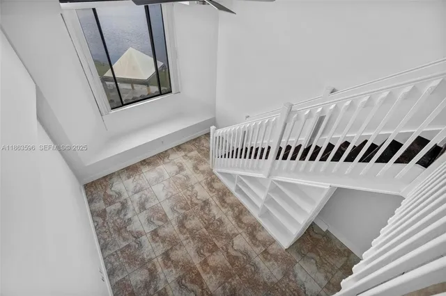a view of a room with a chandelier fan and windows