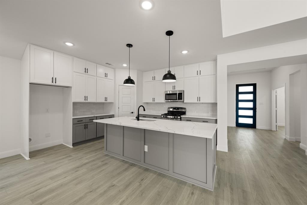 408 Dylan Way Midlothian, TX 76065 - Photo 29 of 40 a large kitchen with stainless steel appliances a sink a stove and a refrigerator